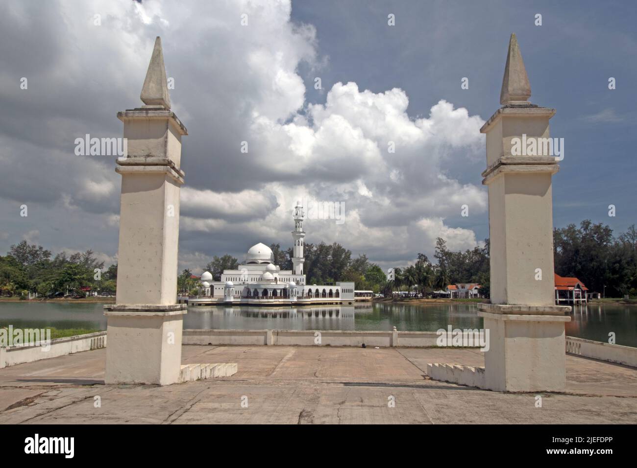 Piliers du pavillon flottant avec la Mosquée flottante de Kuala Ibai sous de lourds nuages à Kuala Ibai à Kuala Terengganu, Malaisie. Banque D'Images