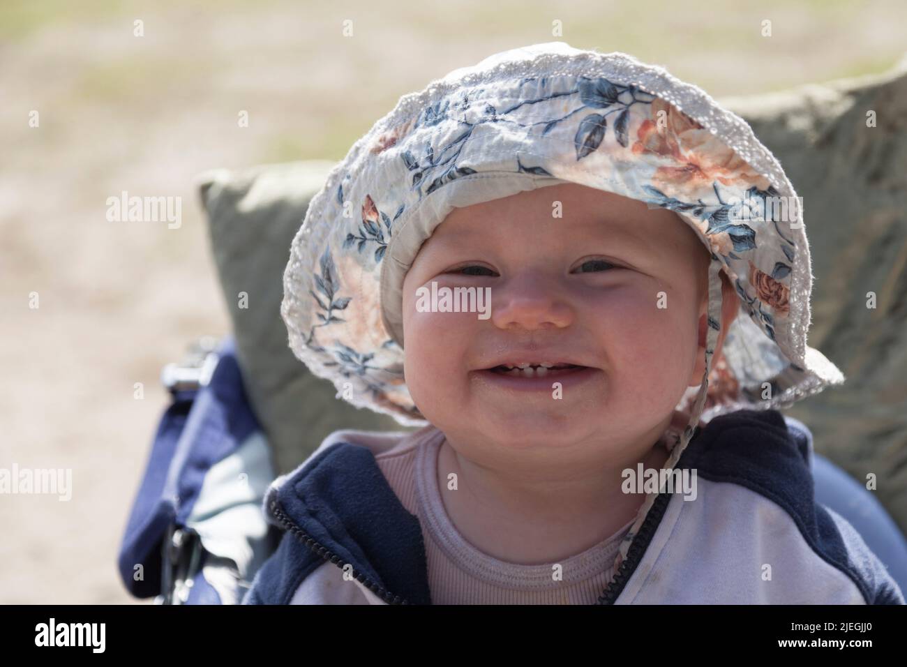 Umea, Norrland Suède - 21 mai 2022 : rire bébé avec de nouvelles dents et un chapeau de soleil Banque D'Images