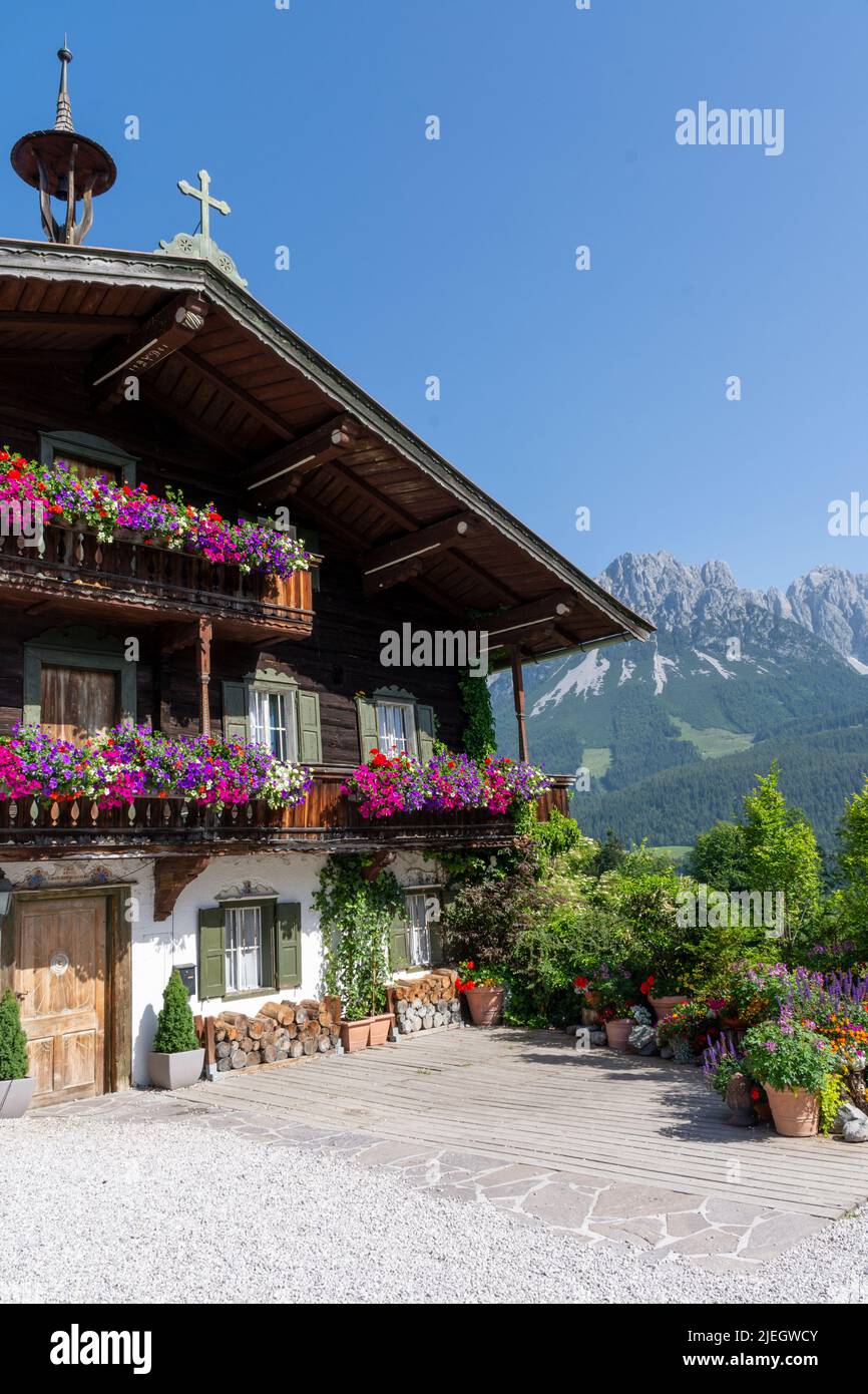 Ellmau, Autriche - 19 juin: Maison traditionnelle en bois utilisée dans la série Bergdoktor et Wilder Kaiser en arrière-plan Banque D'Images