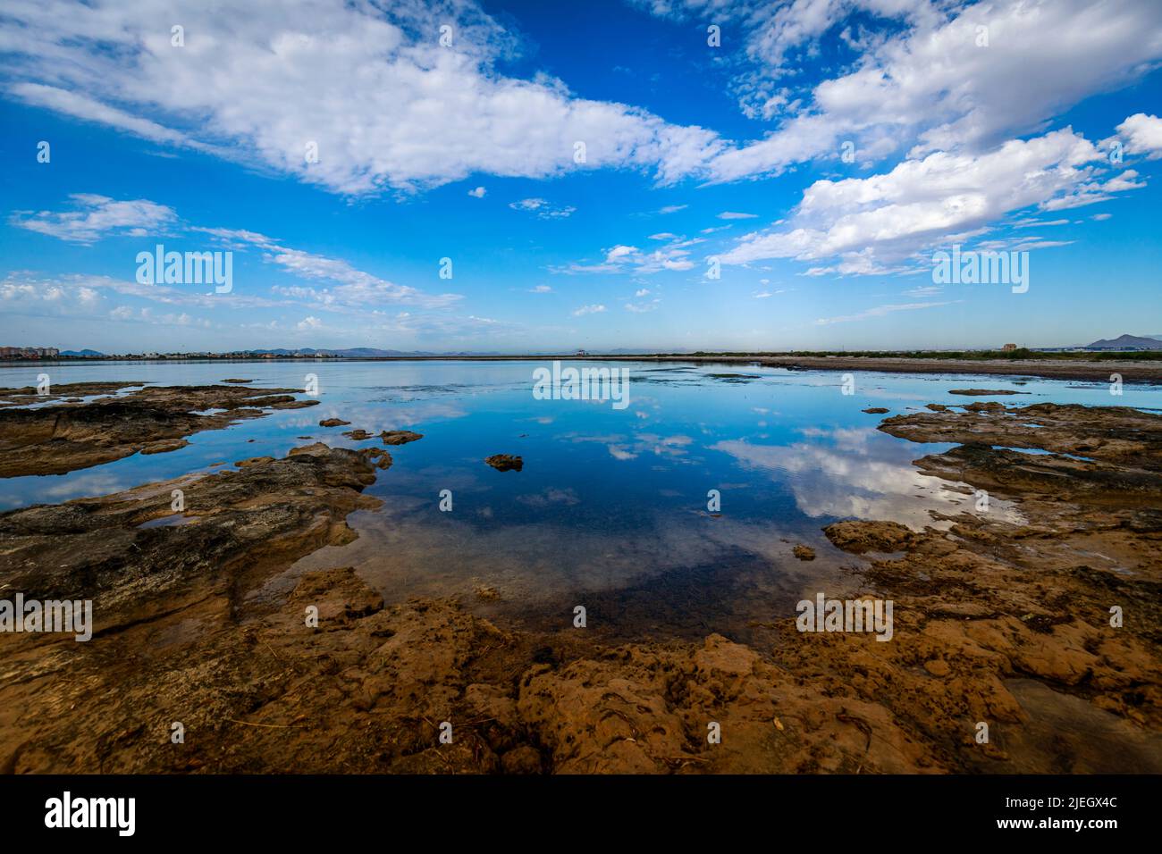 Photo horizontale où vous pouvez voir la côte rocheuse de la Méditerranée avec l'horizon, le ciel bleu intense et illuminé, les nuages blancs, et Banque D'Images