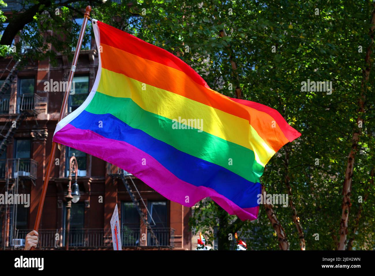 New York, Etats-Unis, 26 juin 2022. Une personne détient un grand drapeau gay Pride 6 couleurs à la NYC Pride March. Banque D'Images