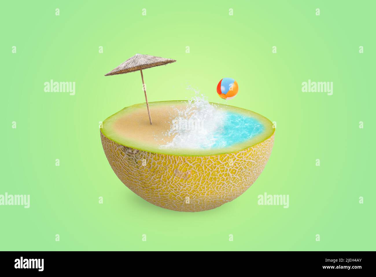 Plage avec vagues, parasol et ballon sur un demi-melon. Le concept de rafraîchissement d'été avec des fruits et des vitamines. Arrière-plan vert Banque D'Images