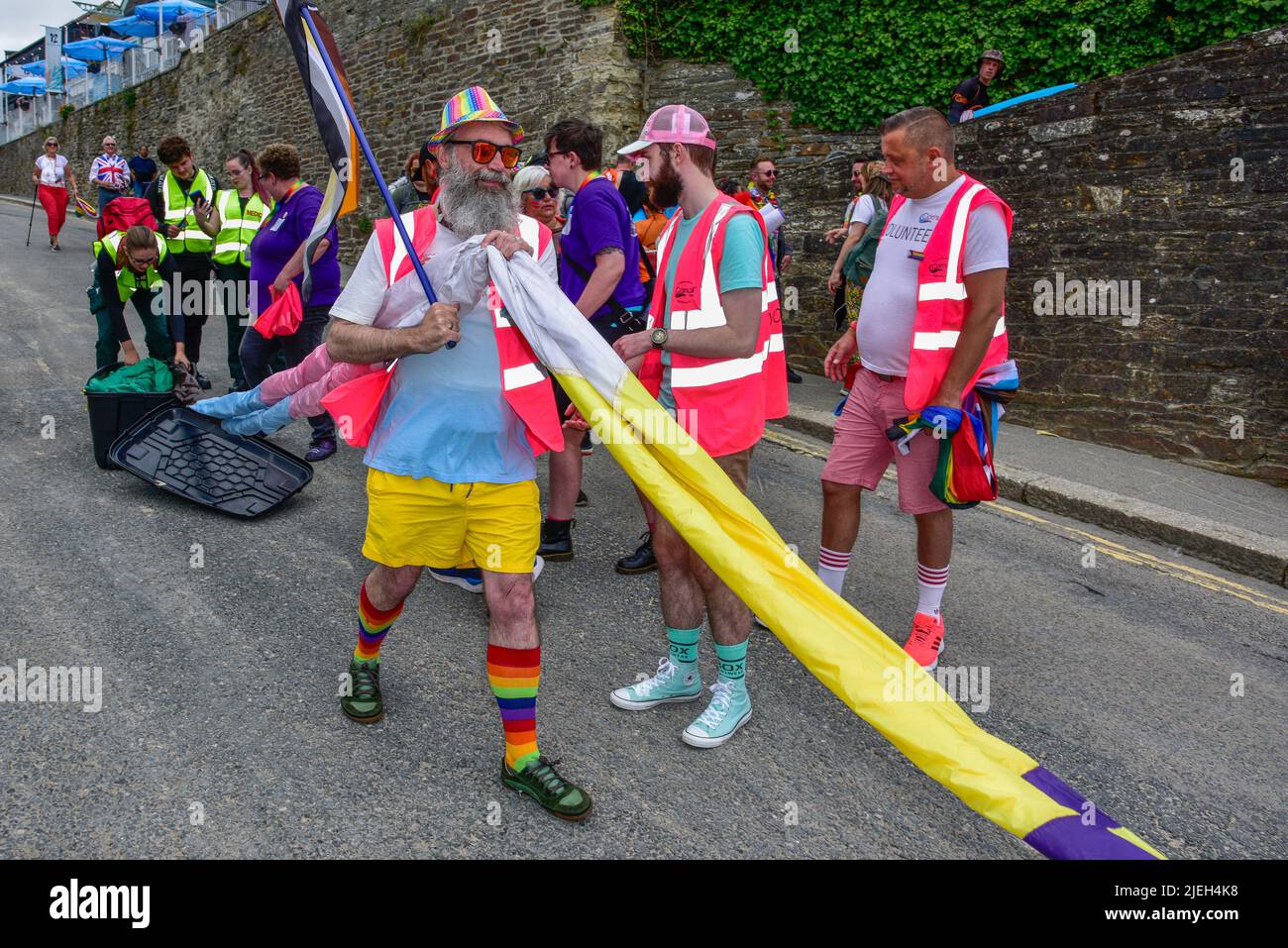 Le drapeau de la fierté gaie, coloré et vibrant, est démené au défilé de la fierté des prides de Cornwall dans le centre-ville de Newquay, au Royaume-Uni. Banque D'Images