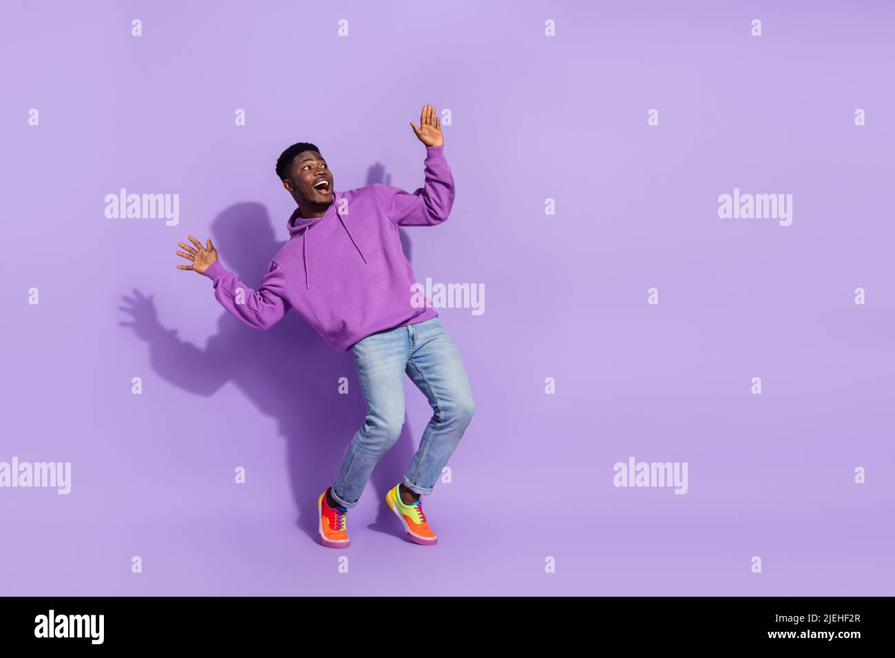 Portrait pleine taille de la personne folle excitée lever les mains look vide espace isolé sur fond violet de couleur Banque D'Images