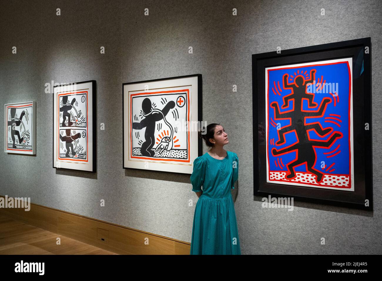 Londres, Royaume-Uni. 27 juin 2022. Un membre du personnel voit (R) “One plate, from grandir”, 1988, par Keith Haring (est. £40 000 - £60 000)' devant “Free South Africa (Untitled 1-3: The Complete Suite)”, 1985, par Keith Haring (est. £50 000 - 70 000 £) à un aperçu de la vente de tirages et de tirages multiples de Bonhams. La vente aux enchères aura lieu le 29 juin dans les galeries de la rue New Bond de Bonhams. Credit: Stephen Chung / Alamy Live News Banque D'Images