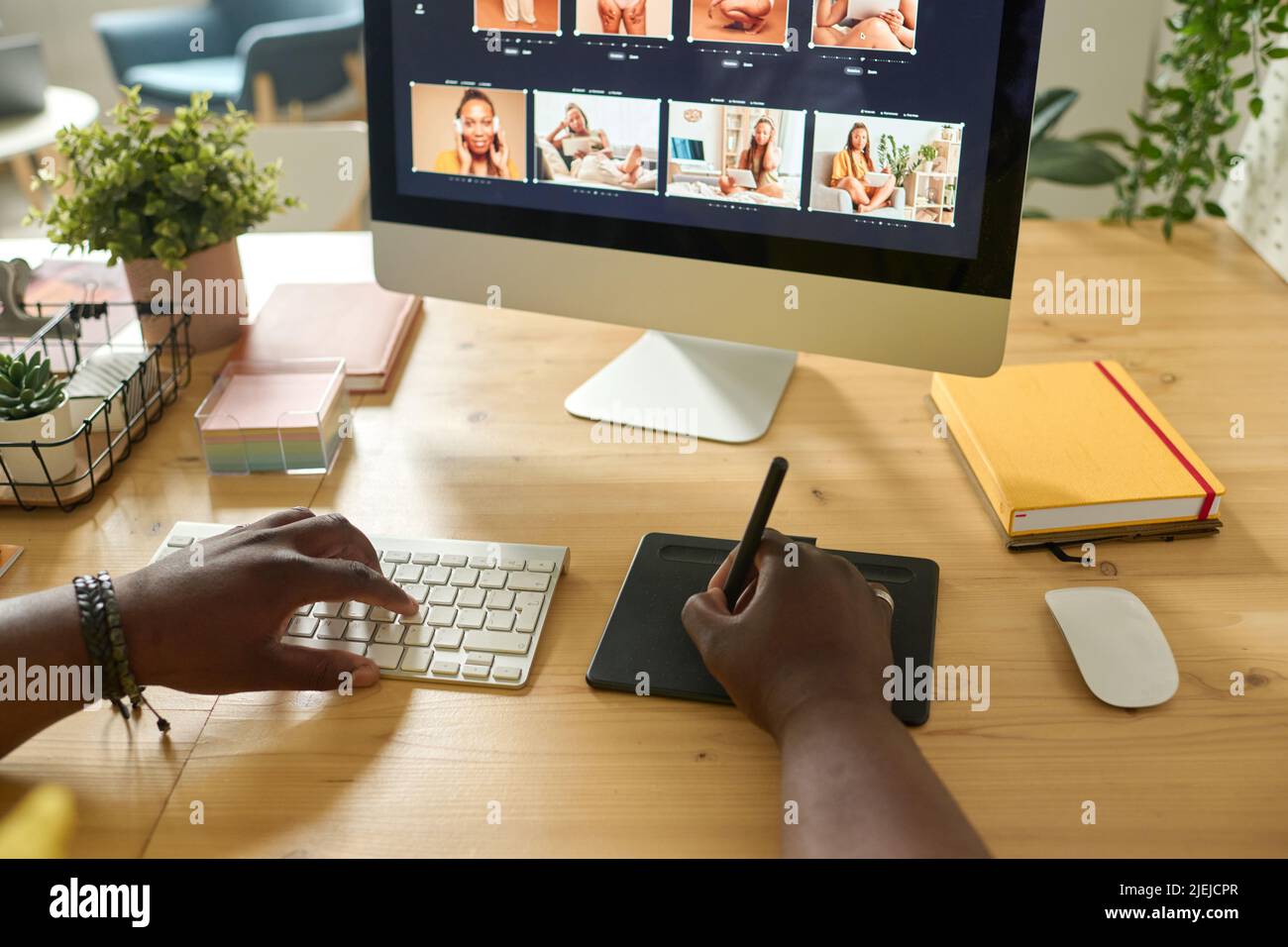 Gros plan de retouche à l'aide d'une tablette graphique pour retoucher des photos sur un écran d'ordinateur à un tableau Banque D'Images