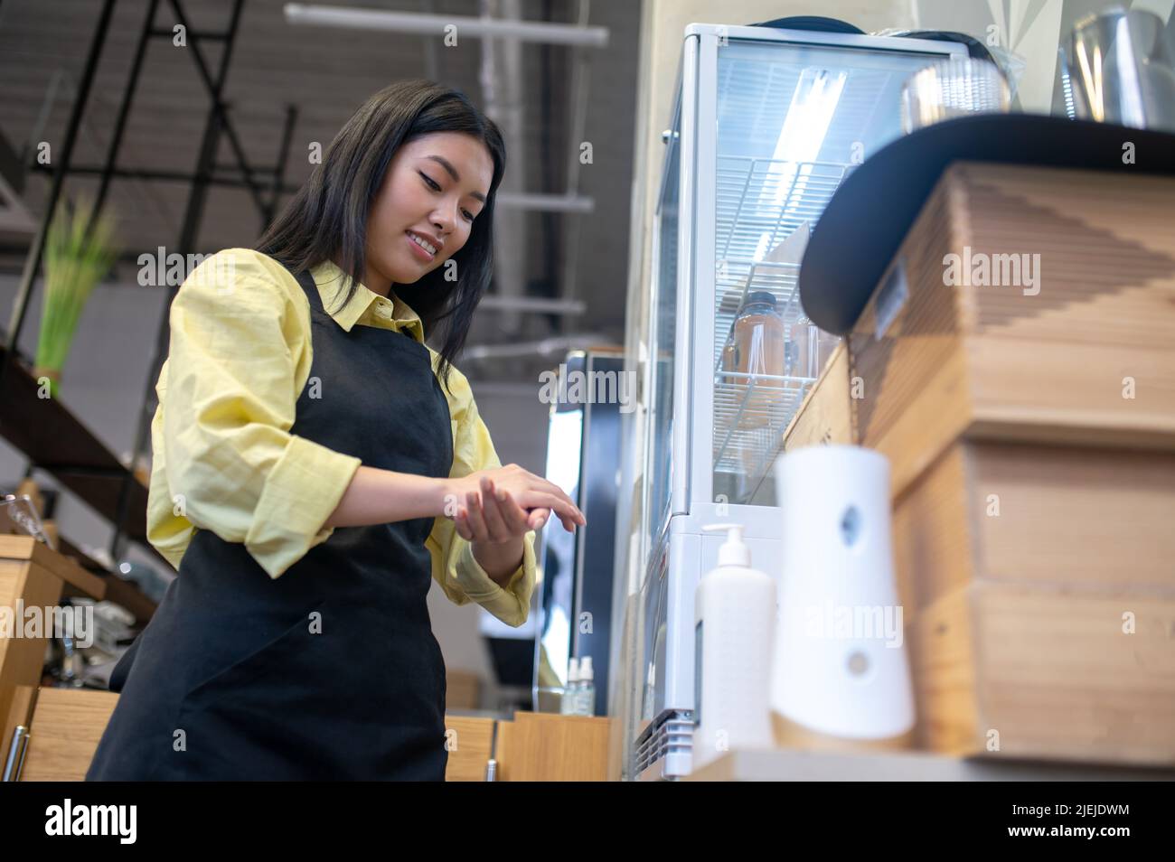 Femme touchant la main à la main avec de l'assainisseur Banque D'Images