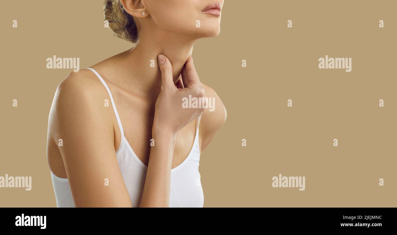 Femme souffrant de mal de gorge, de difficulté à avaler et de perte de voix sur fond beige. Banque D'Images