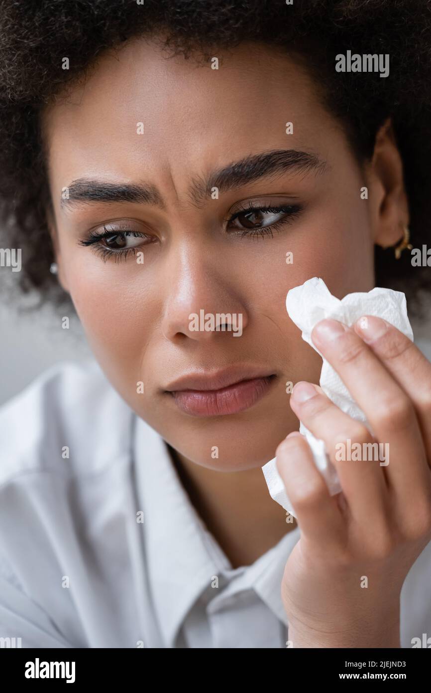 gros plan sur une femme afro-américaine en chemise blanche qui pleure et tient une serviette Banque D'Images