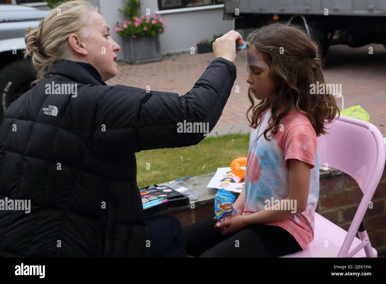 Femme en train de peindre le visage à la reine Elizabeth II Platinum Jubilee Street Party Surrey Angleterre Banque D'Images