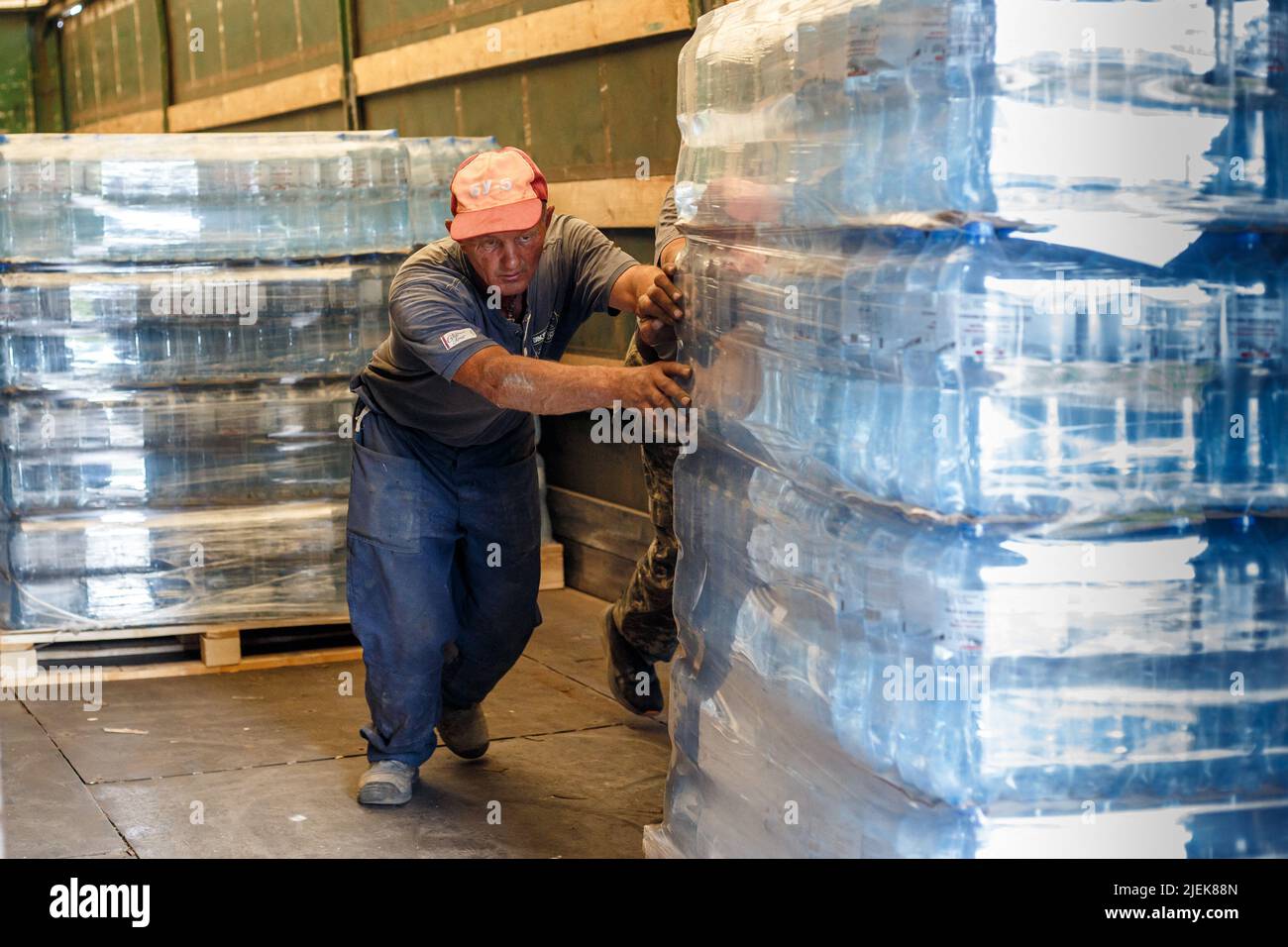 Région de Zakarpattia, Ukraine - 24 juin 2022 - les travailleurs chargent une palette d'eau en bouteille fournie par le Fonds de la mémoire et des racines Zakarpattya d'un camion dans un transport de fret qui livrera la cargaison humanitaire aux villes de l'est de l'Ukraine dévastées par la guerre, région de Zakarpattia, ouest de l'Ukraine. Cette photo ne peut pas être distribuée en Fédération de Russie. Photo de Serhii Hudak/Ukrinform/ABACAPRESS.COM Banque D'Images