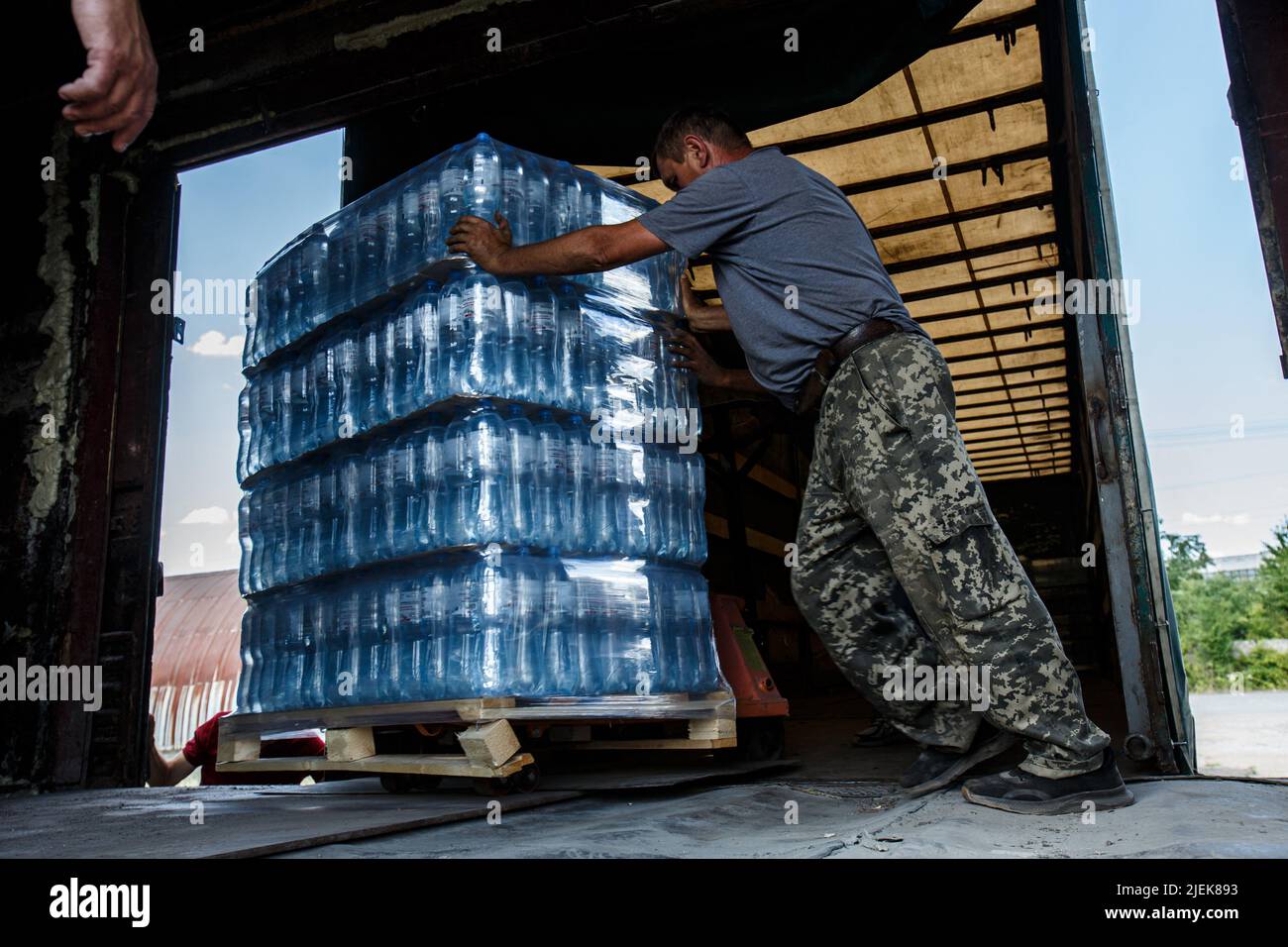 Région de Zakarpattia, Ukraine - 24 juin 2022 - les hommes ont mis une palette d'eau en bouteille fournie par le Fonds de la mémoire et des racines Zakarpattya en place à l'intérieur d'un transporteur de fret qui livrera le fret humanitaire aux villes de l'est de l'Ukraine dévastées par la guerre, région de Zakarpattia, ouest de l'Ukraine. Cette photo ne peut pas être distribuée en Fédération de Russie. Photo de Serhii Hudak/Ukrinform/ABACAPRESS.COM Banque D'Images