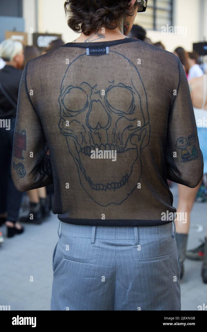 MILAN, ITALIE - 18 JUIN 2022 : un homme avec une chemise à filet noir Canaku et un tatouage au crâne avant le défilé de mode du comté de Marcelo Burlon de Milan, la semaine de la mode de Milan Banque D'Images