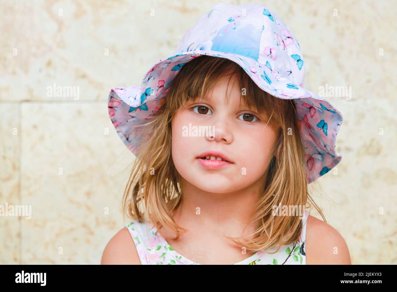 Jolie petite fille européenne en chapeau Panama coloré, gros plan visage portrait Banque D'Images
