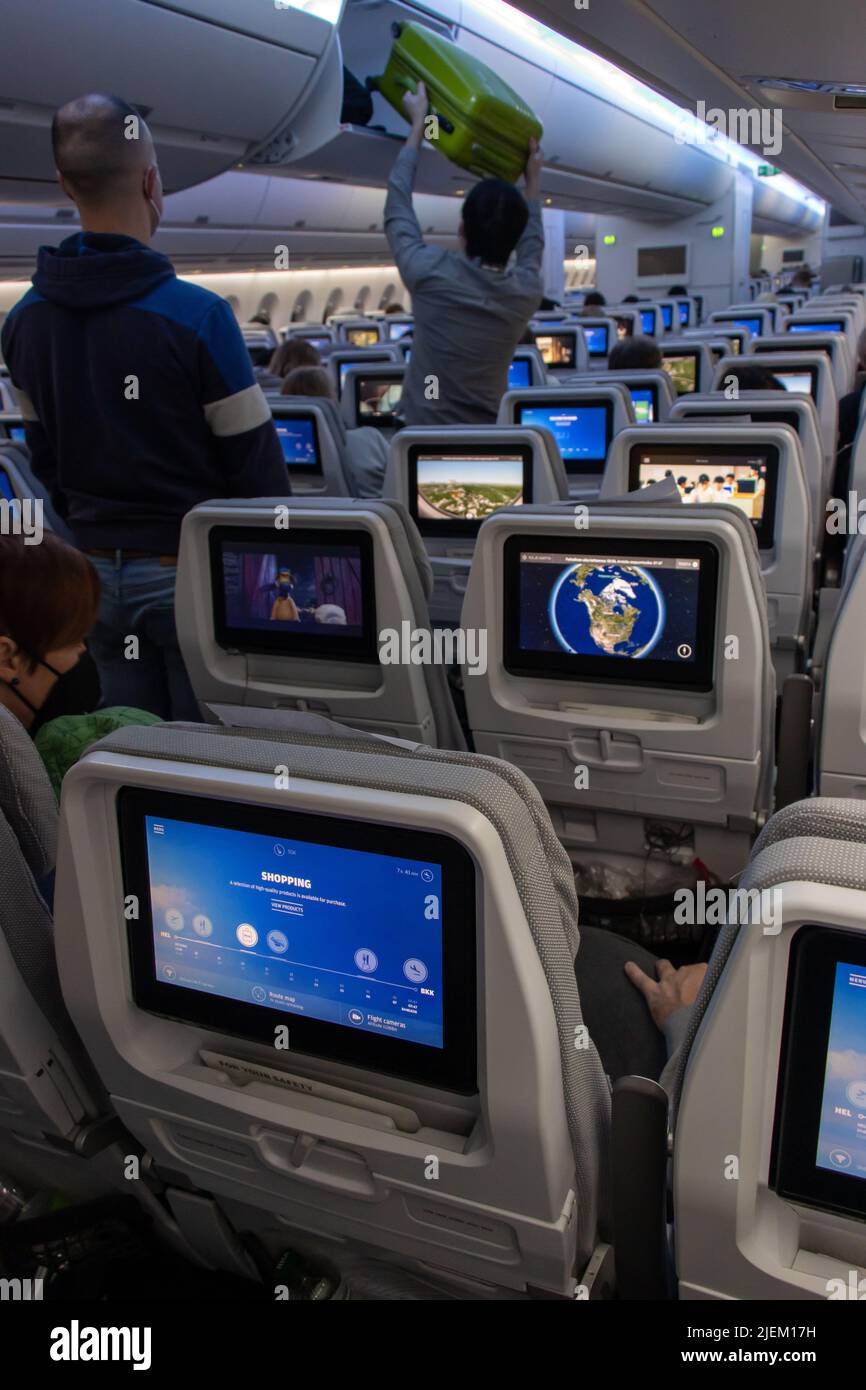 Intérieur d'un avion volant avec moniteurs sur les sièges Banque D'Images