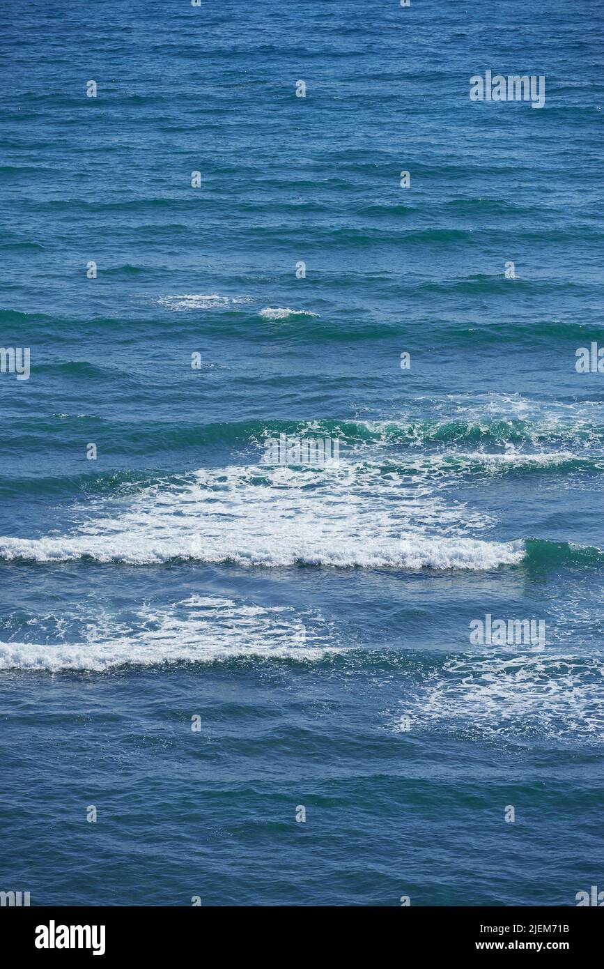 Vagues calmes dans l'océan vide, par temps ensoleillé. Belle eau de mer avec des effets d'ondulation de lumière sur la surface. Abstrait aqua textures dans le profond large Banque D'Images