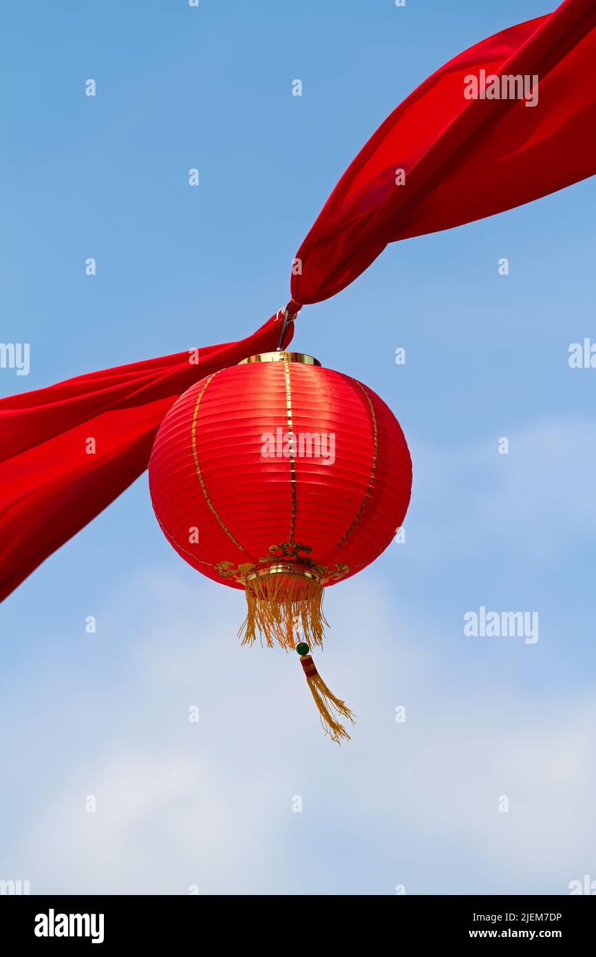 Lanterne chinoise rouge dans l'air décorant les rues de Chine. Décor asiatique traditionnel pour les célébrations du nouvel an dans un magnifique ciel Banque D'Images