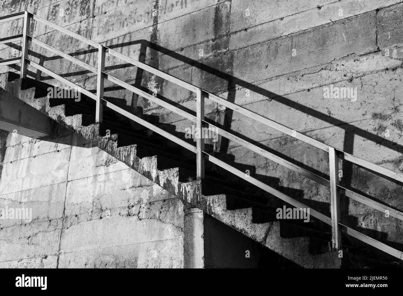 La perspective et l'ombre de l'escalier en béton grundy sur le mur. Photo d'architecture abstraite en noir et blanc Banque D'Images