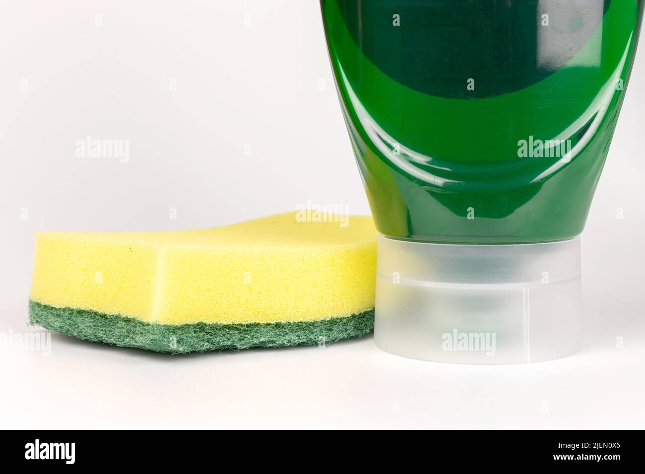 Lave-vaisselle liquide vert avec une éponge dans une bouteille à l'envers vue avant Banque D'Images
