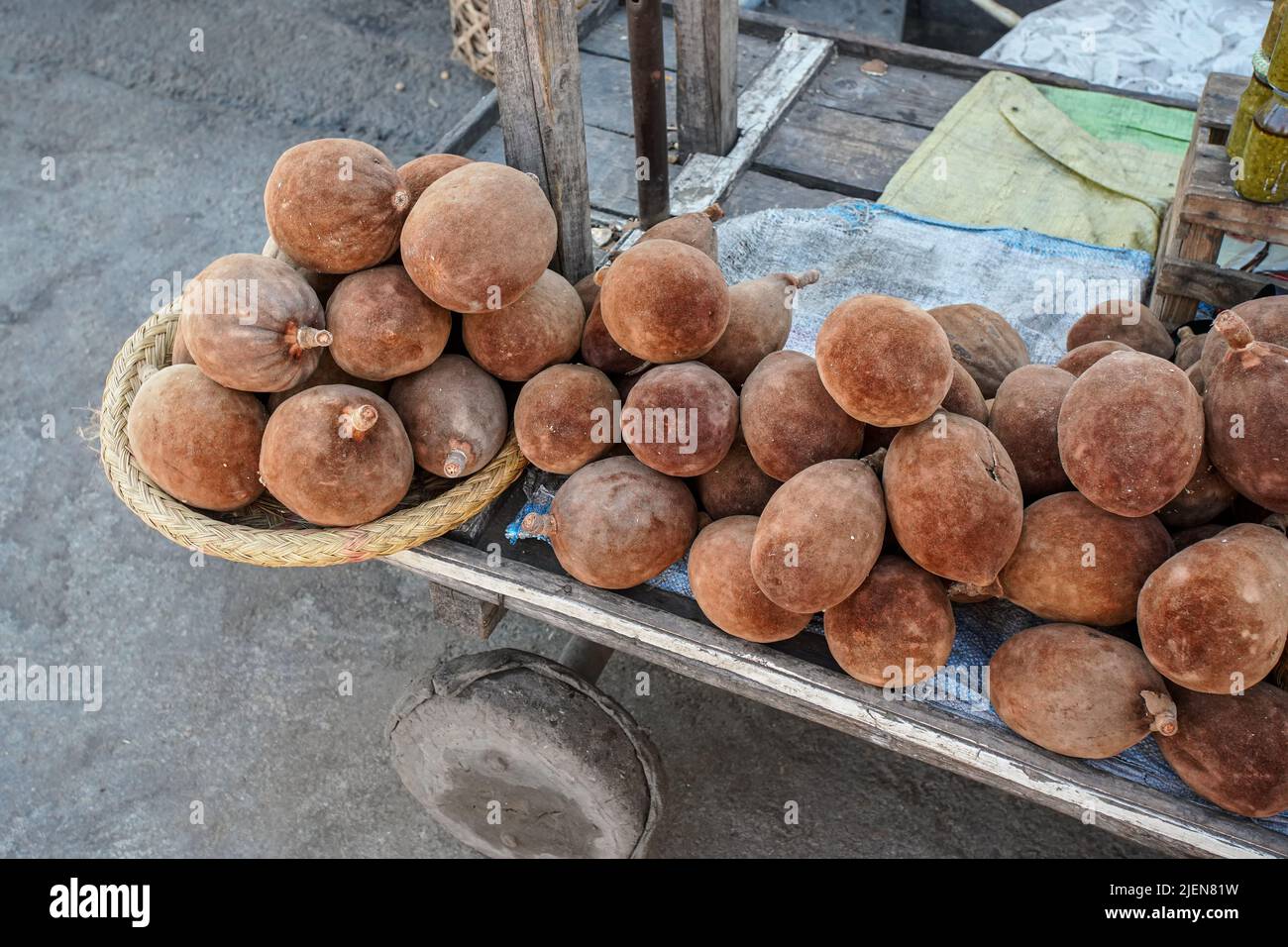 Baobab brun clair fruits exposés au marché de rue, tas placé sur simple chariot en bois, détail de gros plan Banque D'Images