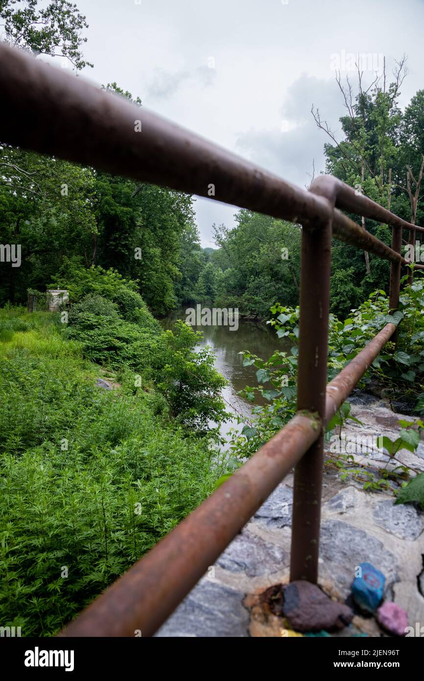 Le vieux pont en bois se dresse au-dessus de la rivière qui coule doucement Banque D'Images