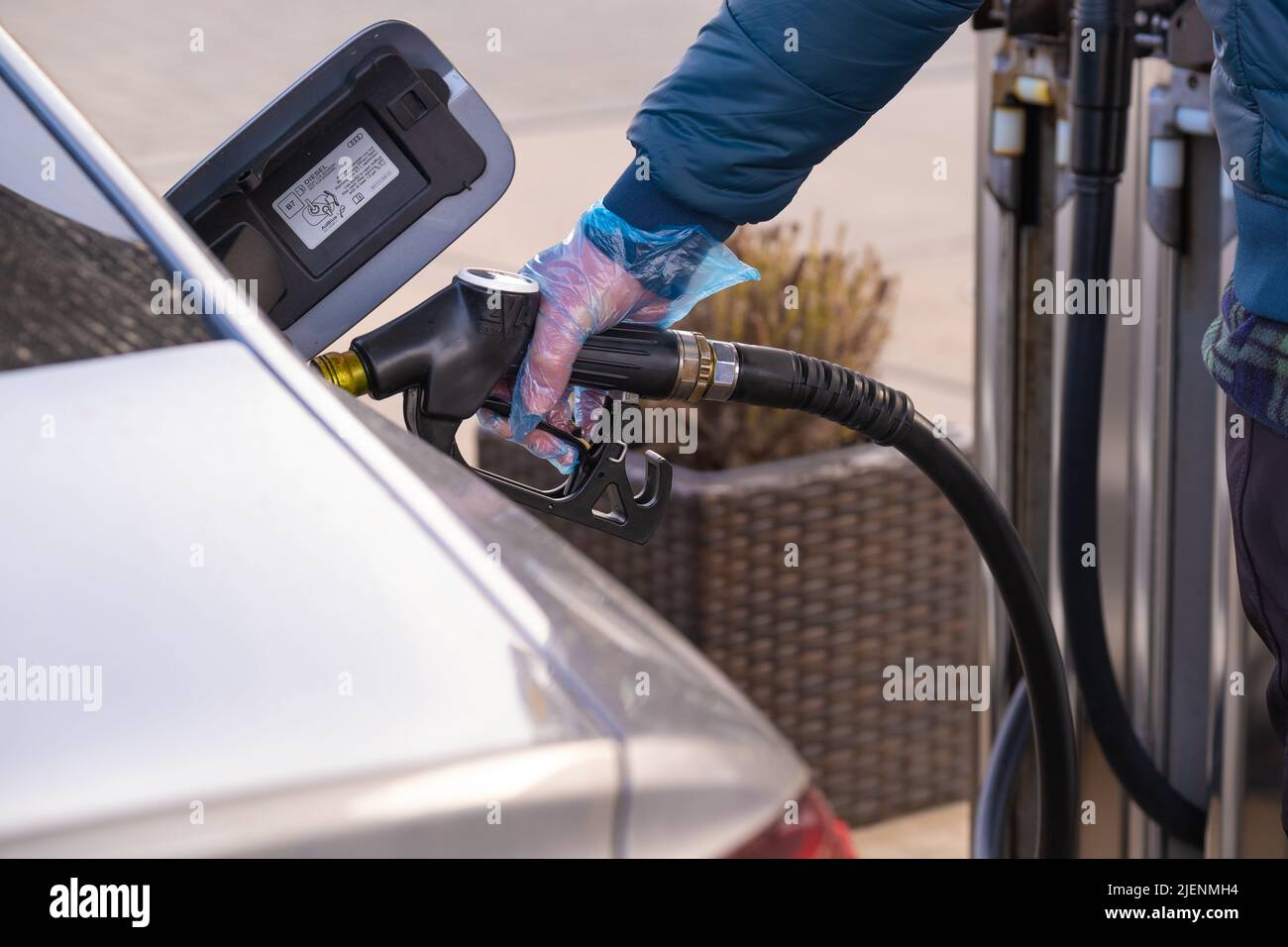 Diesel.Prix du carburant en Europe. Ravitaillement de la voiture.pistolet de ravitaillement dans les mains d'un homme dans un gant bleu.voiture à une station-service. Voiture argent, ravitaillement Banque D'Images