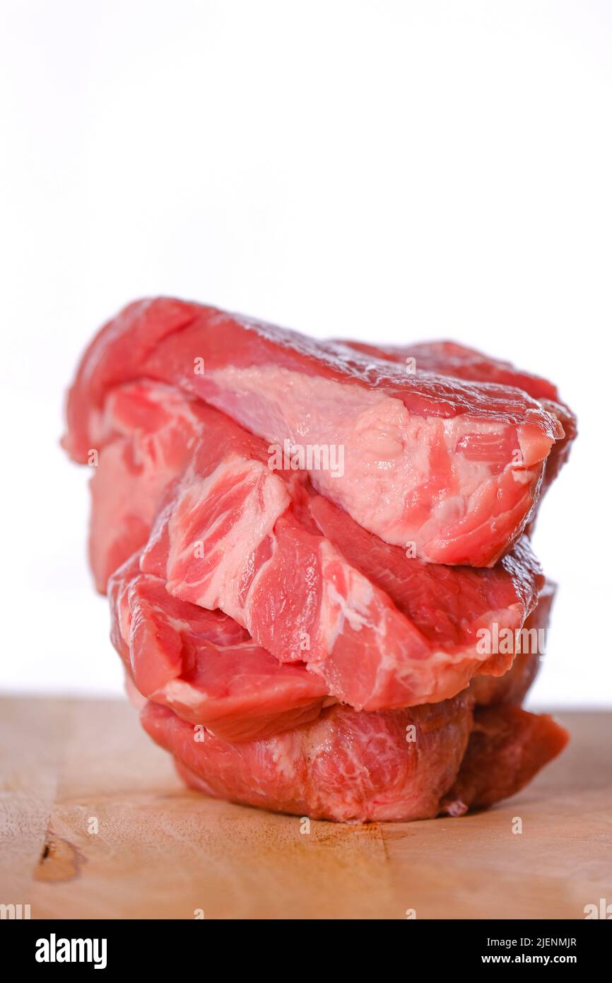 Morceaux de viande sur une planche à découper en bois.cuisson de produits de viande.viande crue sur une planche à découper. Viande hachée sur fond blanc. Banque D'Images