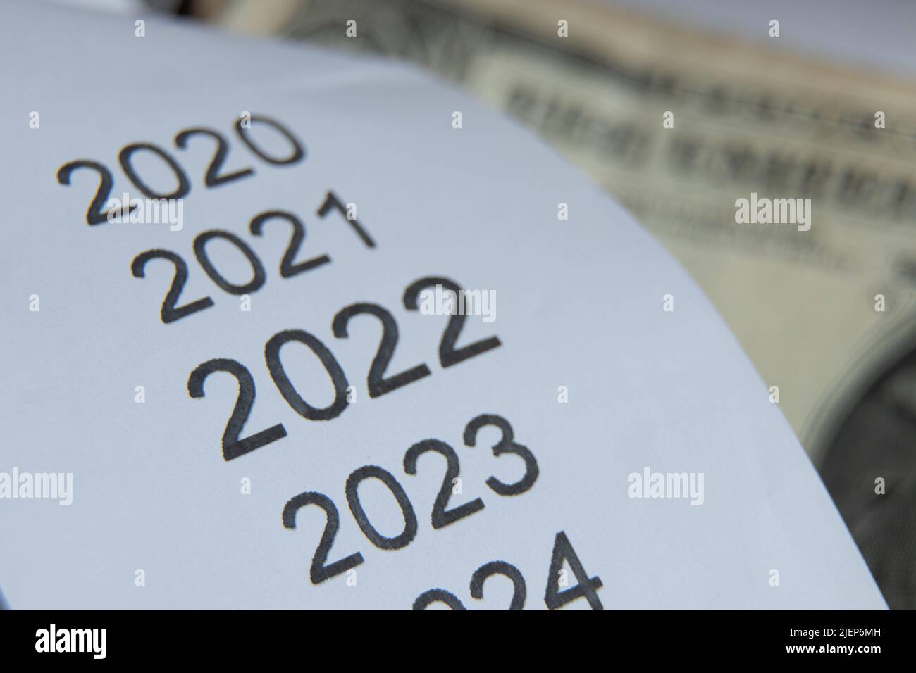 Liste des années 2020 2021 2022 2023 sur la caisse qui se trouve près des dollars américains, le reçu des ventes et l'argent, le sujet financier, les revenus en 2022 Banque D'Images