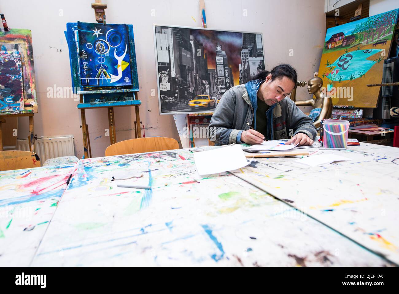 Rotterdam, pays-Bas. Un client de réinsertion masculin de via Kunst projet de Pauluskerk travaillant sur une table de studio d'art sur la création d'une nouvelle œuvre d'art et d'art, qui peut être vendu dans le magasin d'avant et boutique d'art en bas ville. Banque D'Images