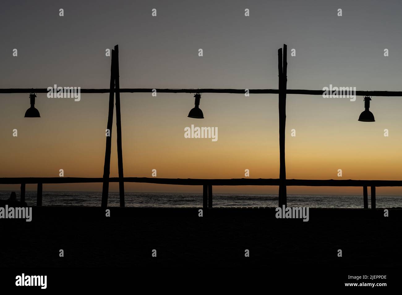 Une silhouette d'une jetée en bois avec des lampes suspendues au coucher du soleil à Swakopmund, Namibie Banque D'Images