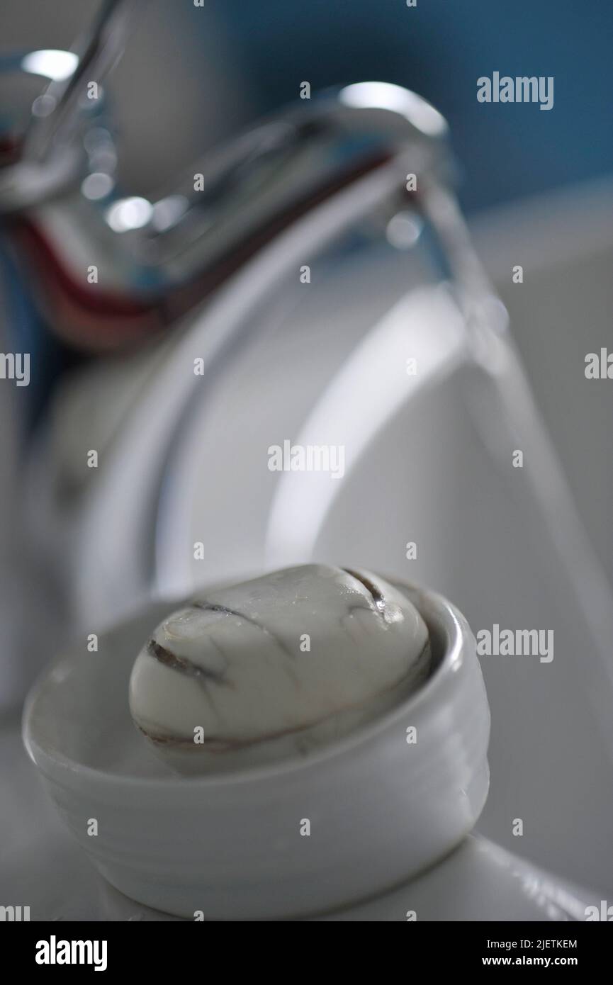 eau courante du robinet avec du savon sale dans un porte-savon au premier plan Banque D'Images