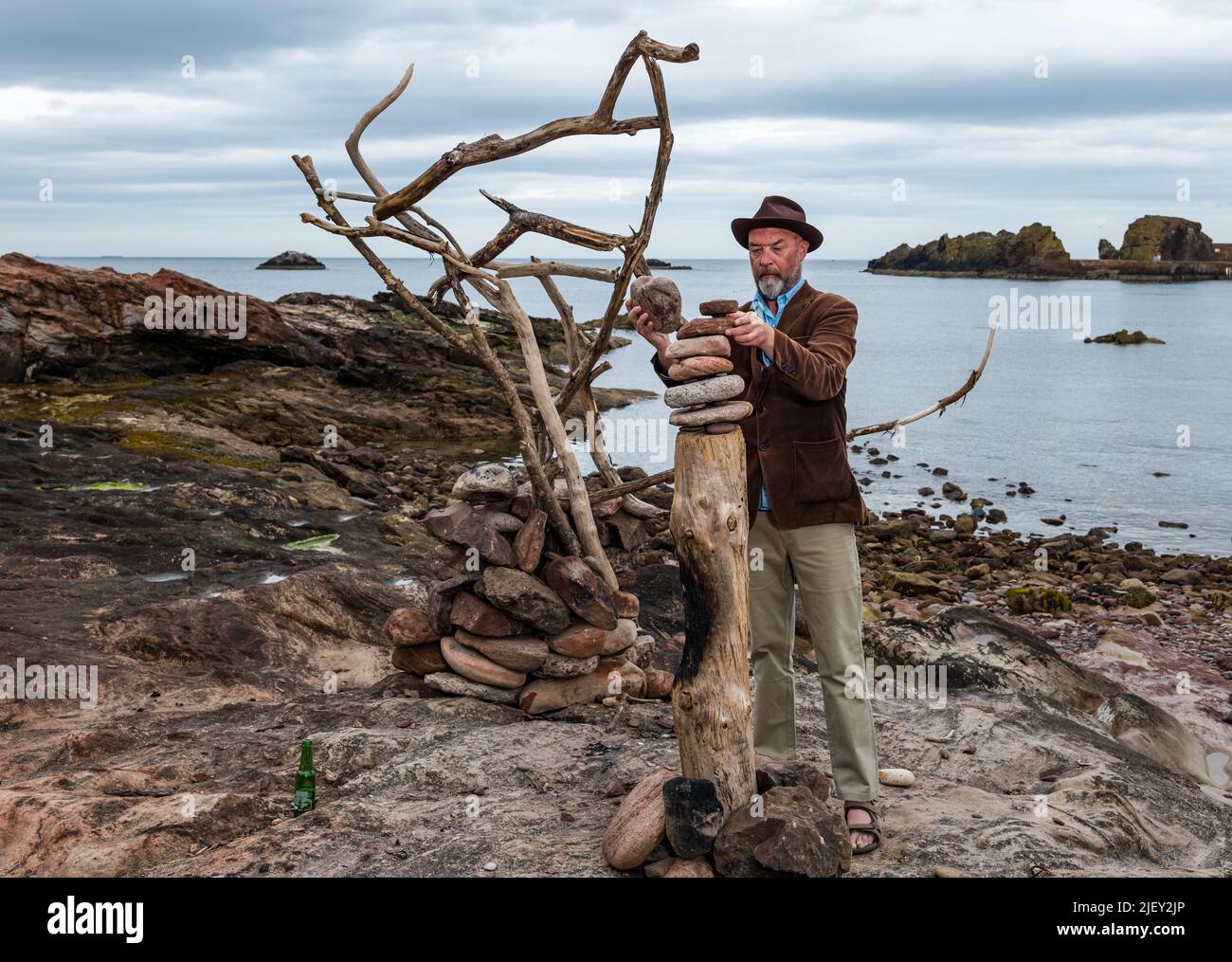 Dunbar, East Lothian, Écosse, Royaume-Uni, 28th juin 2022. Festival européen des arts terrestres et championnats européens de picking de pierre : l'ESSC annuel de cette année est devenu un festival d'art terrestre d'une semaine qui commence lundi prochain dans les lieux de la ville. L'organisateur James Craig page crée quelques installations sur la plage Eye Cave en préparation de l'événement. Les participants viennent du monde entier. Photo : James Craig page, fondateur de l'événement Banque D'Images