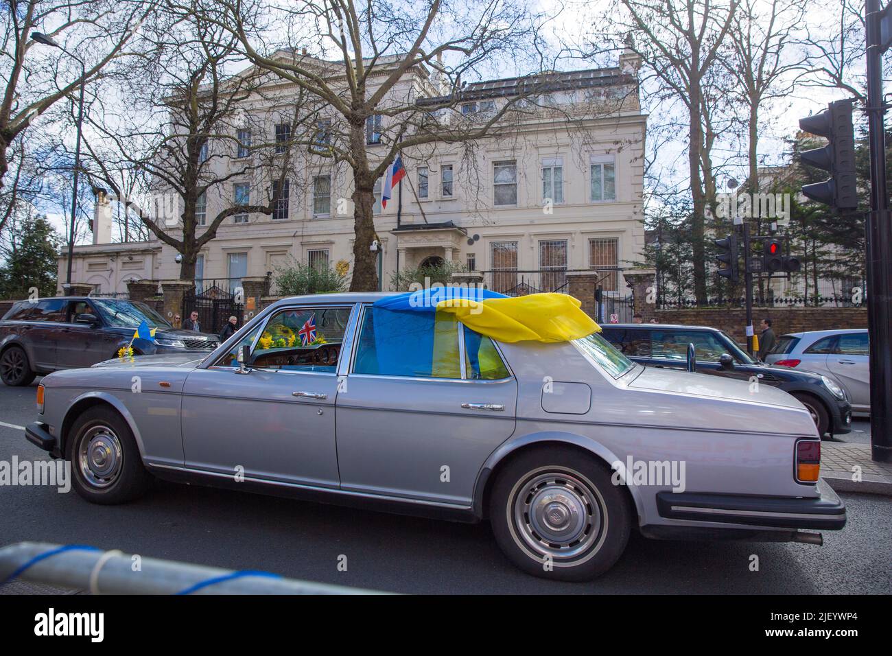 Une voiture affichant des drapeaux ukrainiens se présente pour protester contre l’invasion de l’Ukraine par la Russie près de l’ambassade de Russie à Londres. Banque D'Images