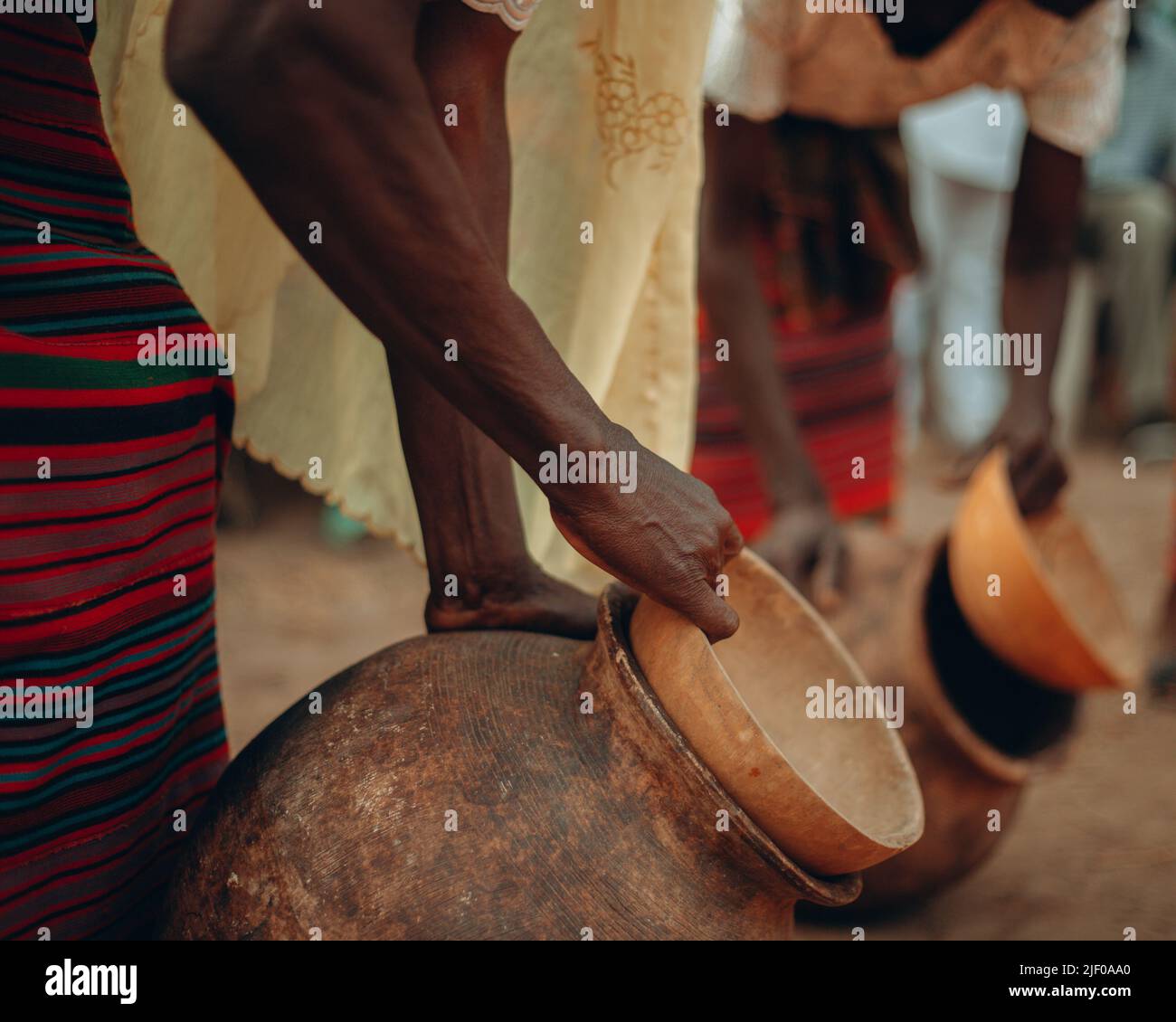 Un gros plan de femmes tenant la poterie africaine pleine d'eau Banque D'Images