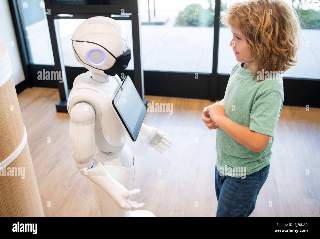 un petit garçon interagit avec l'intelligence artificielle du robot, l'interaction Banque D'Images