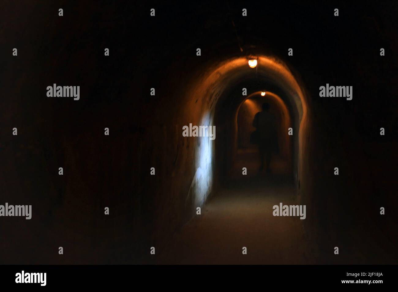 Une scène sombre hors foyer avec ce qui apparaît comme une figure fantôme marchant sous l'arche. Banque D'Images