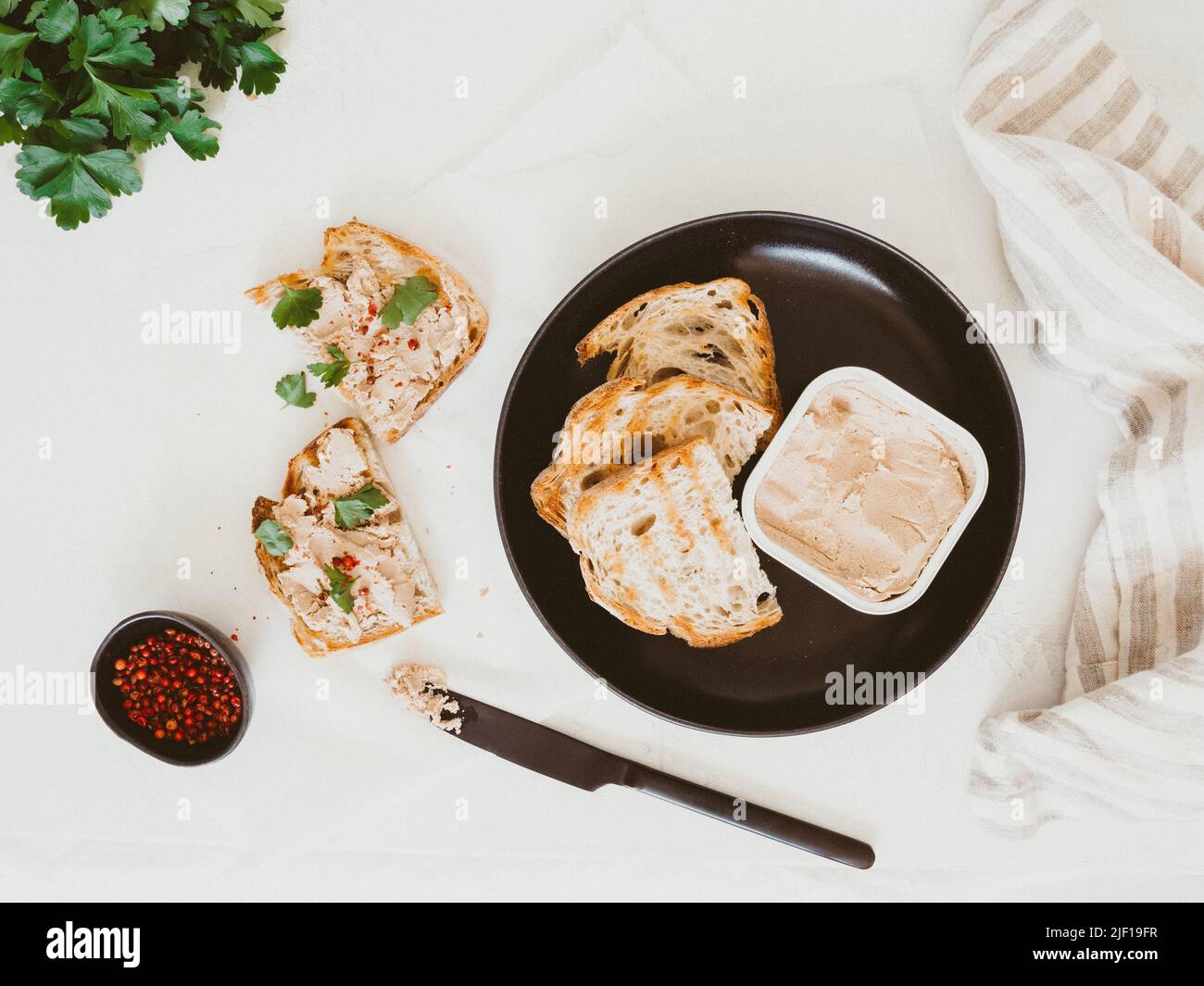 Pâté de foie de poulet maison frais sur pain grillé maison avec persil et épices sur la table. Vue de dessus Banque D'Images