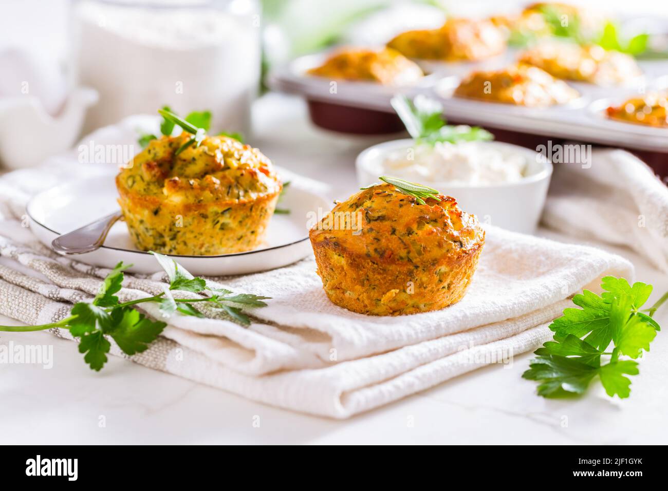 Délicieux muffins au courgettes maison avec fromage feta sur une table de cuisine blanche Banque D'Images