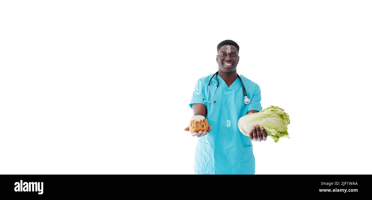 Un médecin afro-américain sur fond blanc avec des bonbons verts entre ses mains. Banque D'Images