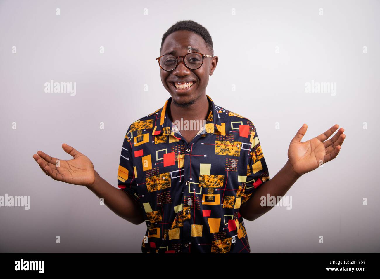Homme d'affaires africain aux armes ouvertes et expression surprise, photo prise en studio Banque D'Images