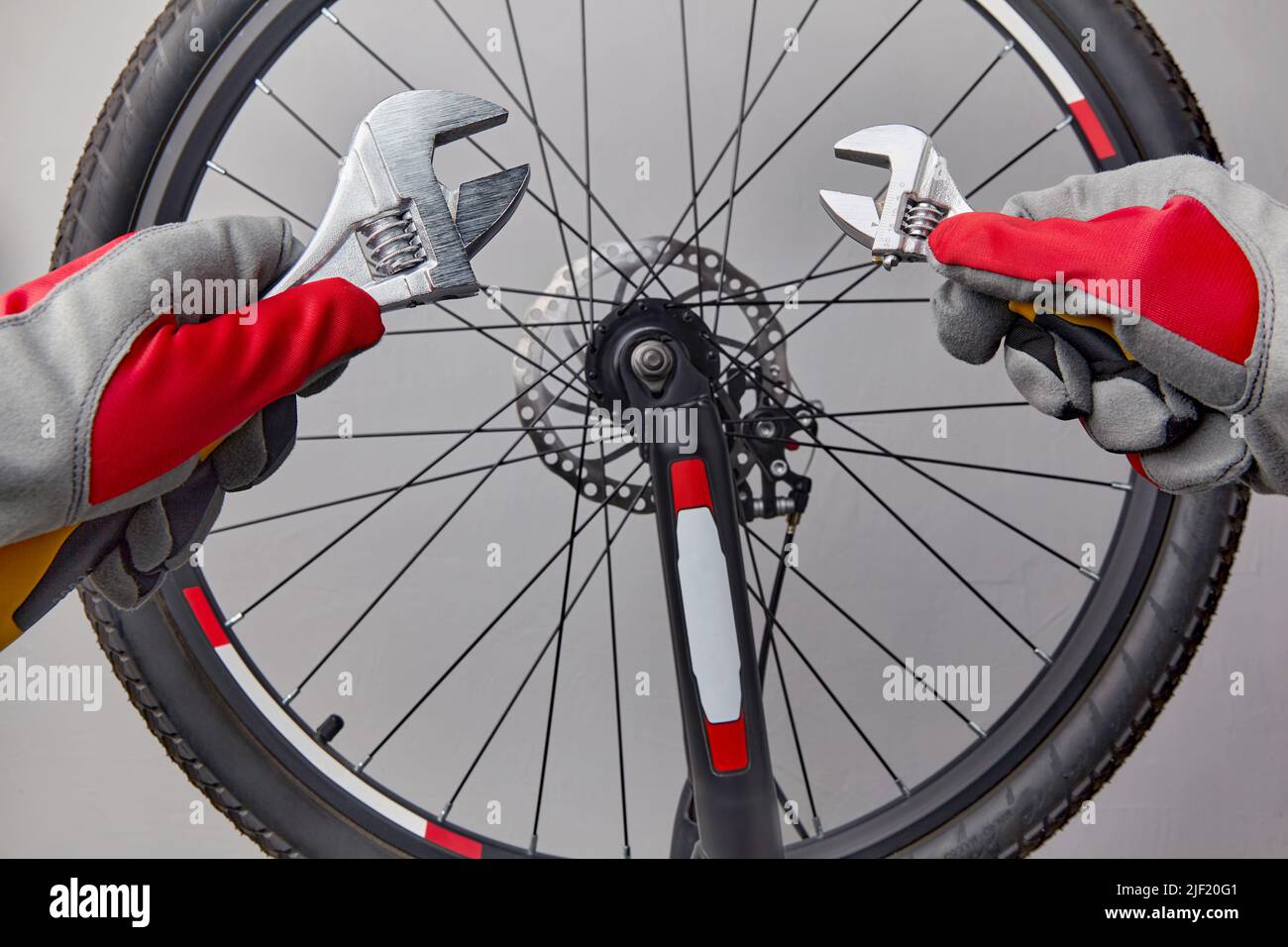 Mains dans des gants de protection avec clés réglables sur un vélo Banque D'Images