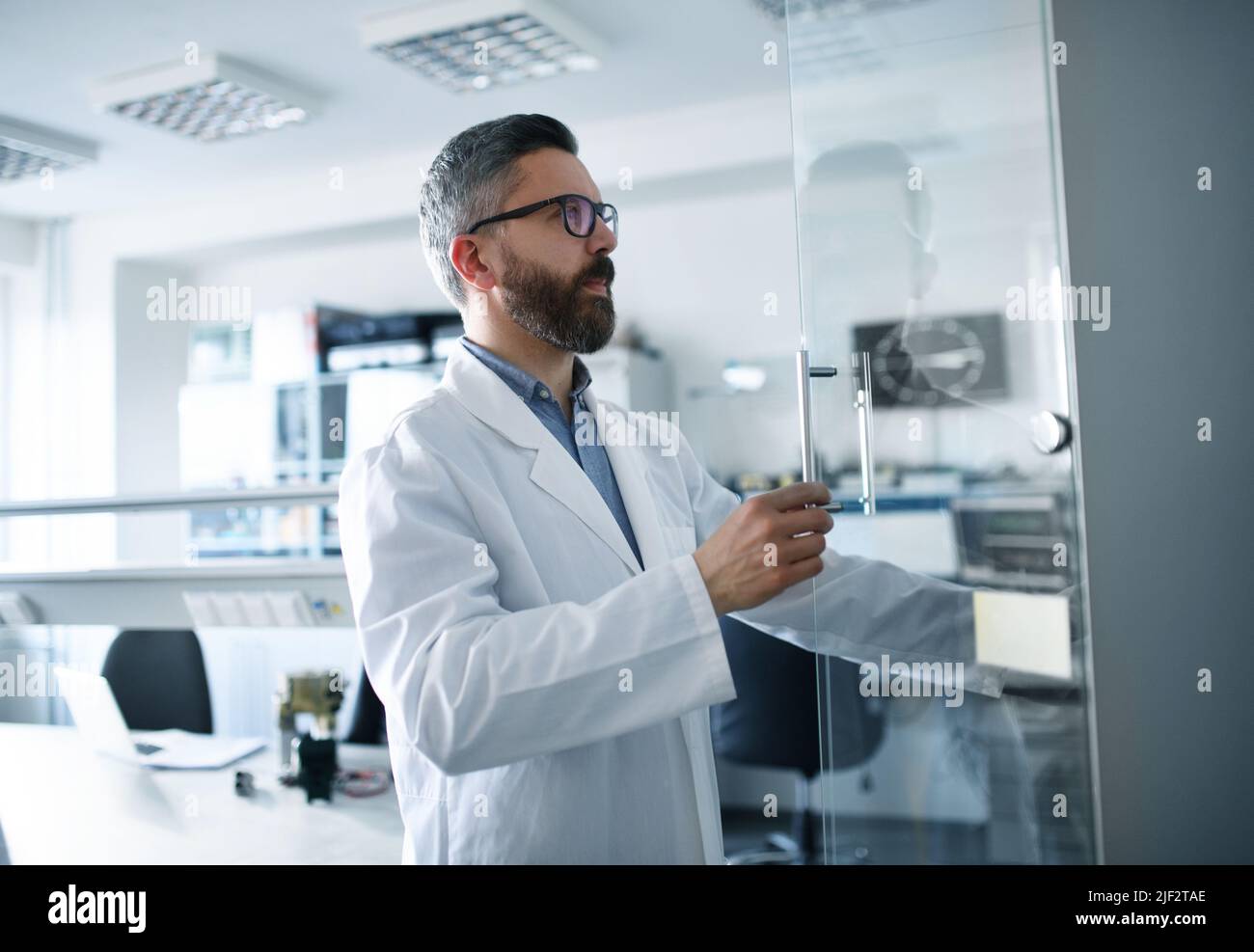Ingénieur en robotique travaillant sur le détage d'un bras robotique moderne en laboratoire. Banque D'Images