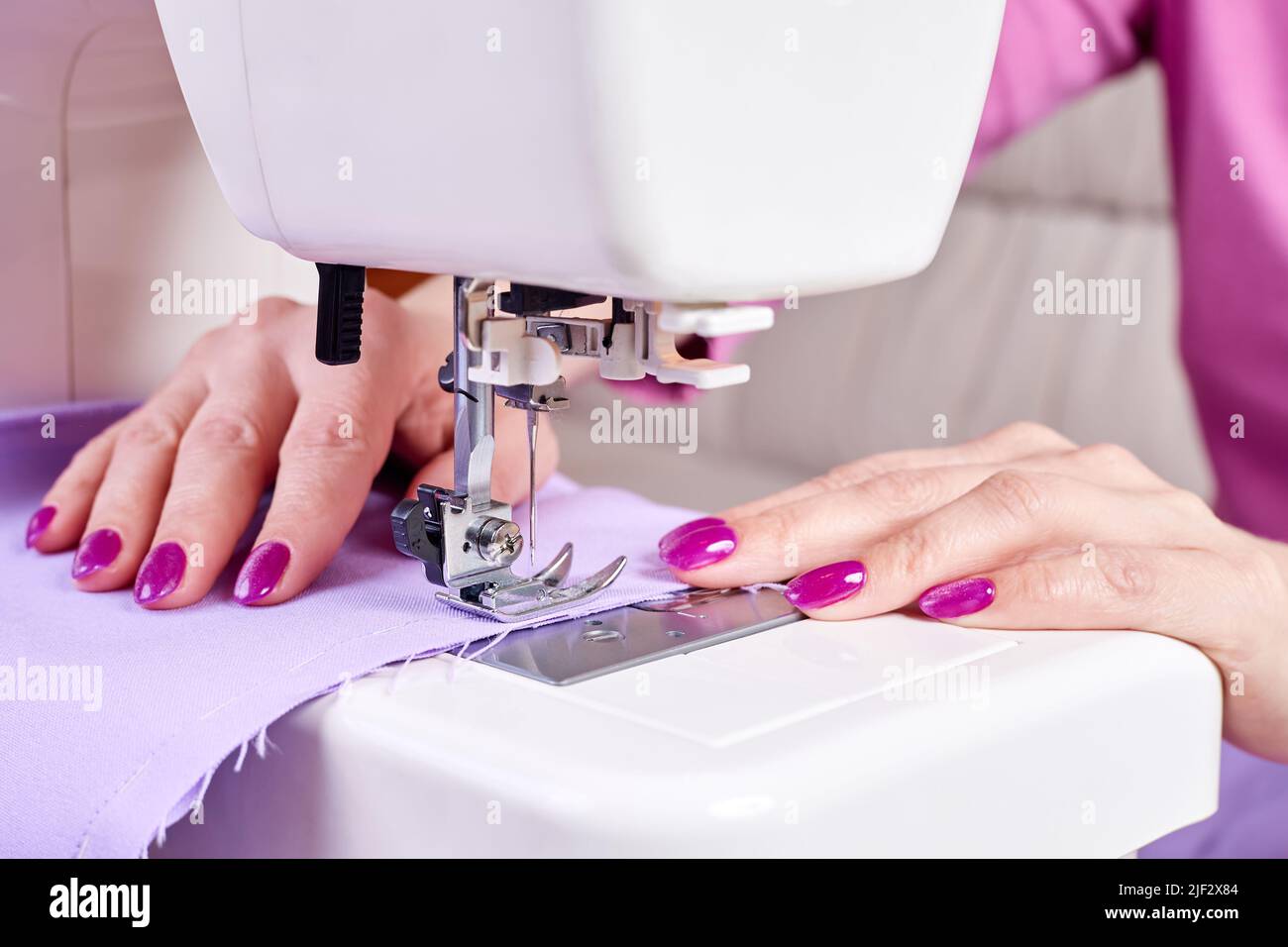 Femme coudre une robe sur une machine à coudre. Gros plan, mise au point  sélective Photo Stock - Alamy