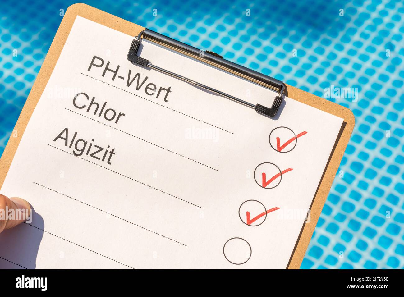 Vérification de la qualité de l'eau d'une piscine avec le texte en langue allemande pour la valeur de pH, le chlore et l'acide algique Banque D'Images