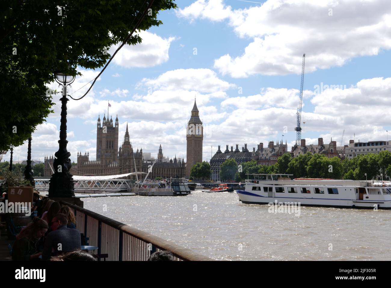 À côté de la Tamise, la rive sud est une zone dynamique au cœur de la scène culturelle de Londres. Le Southbank Center, le Théâtre national et le cinéma BFI sont des lieux artistiques de classe mondiale. La promenade au bord de la rivière est bordée d'arbres, de restaurants et de pubs historiques, et est le site de foires et d'événements fréquents. Les touristes admirent des sites emblématiques tels que Big Ben et la cathédrale Saint-Paul depuis la grande roue London Eye .. Banque D'Images