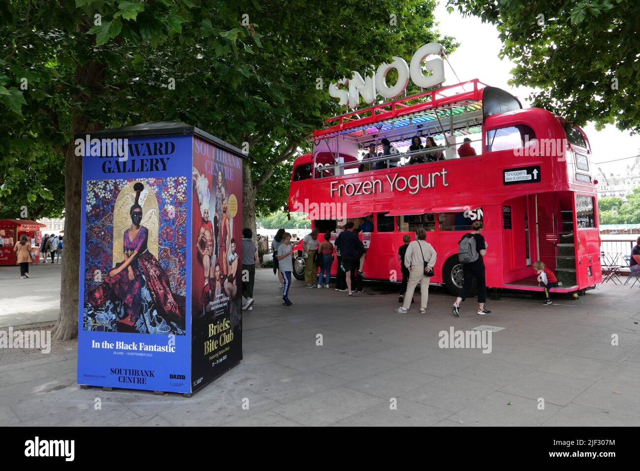 À côté de la Tamise, la rive sud est une zone dynamique au cœur de la scène culturelle de Londres. Le Southbank Center, le Théâtre national et le cinéma BFI sont des lieux artistiques de classe mondiale. La promenade au bord de la rivière est bordée d'arbres, de restaurants et de pubs historiques, et est le site de foires et d'événements fréquents. Les touristes admirent des sites emblématiques tels que Big Ben et la cathédrale Saint-Paul depuis la grande roue London Eye .. Banque D'Images