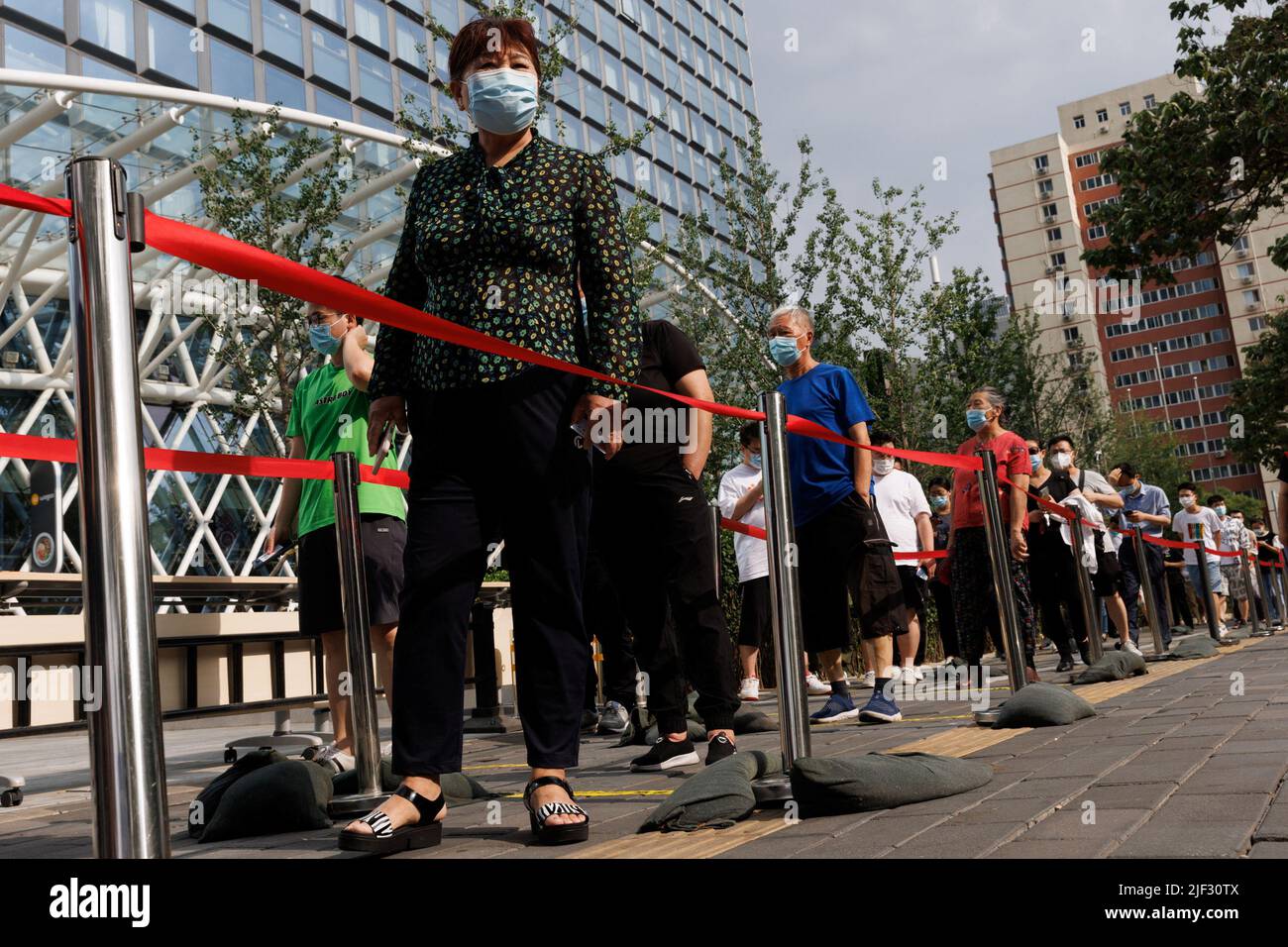 Les gens font la queue dans une station de dépistage des acides nucléiques, après une éclosion de coronavirus (COVID-19), à Beijing, en Chine, au 29 juin 2022. REUTERS/Thomas Peter Banque D'Images