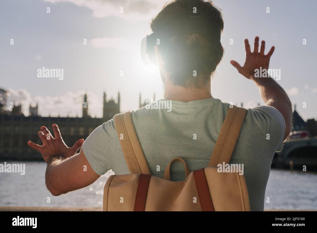 Vue arrière d'un homme à l'aide d'un casque de réalité virtuelle tout en explorant la ville de Londres Banque D'Images