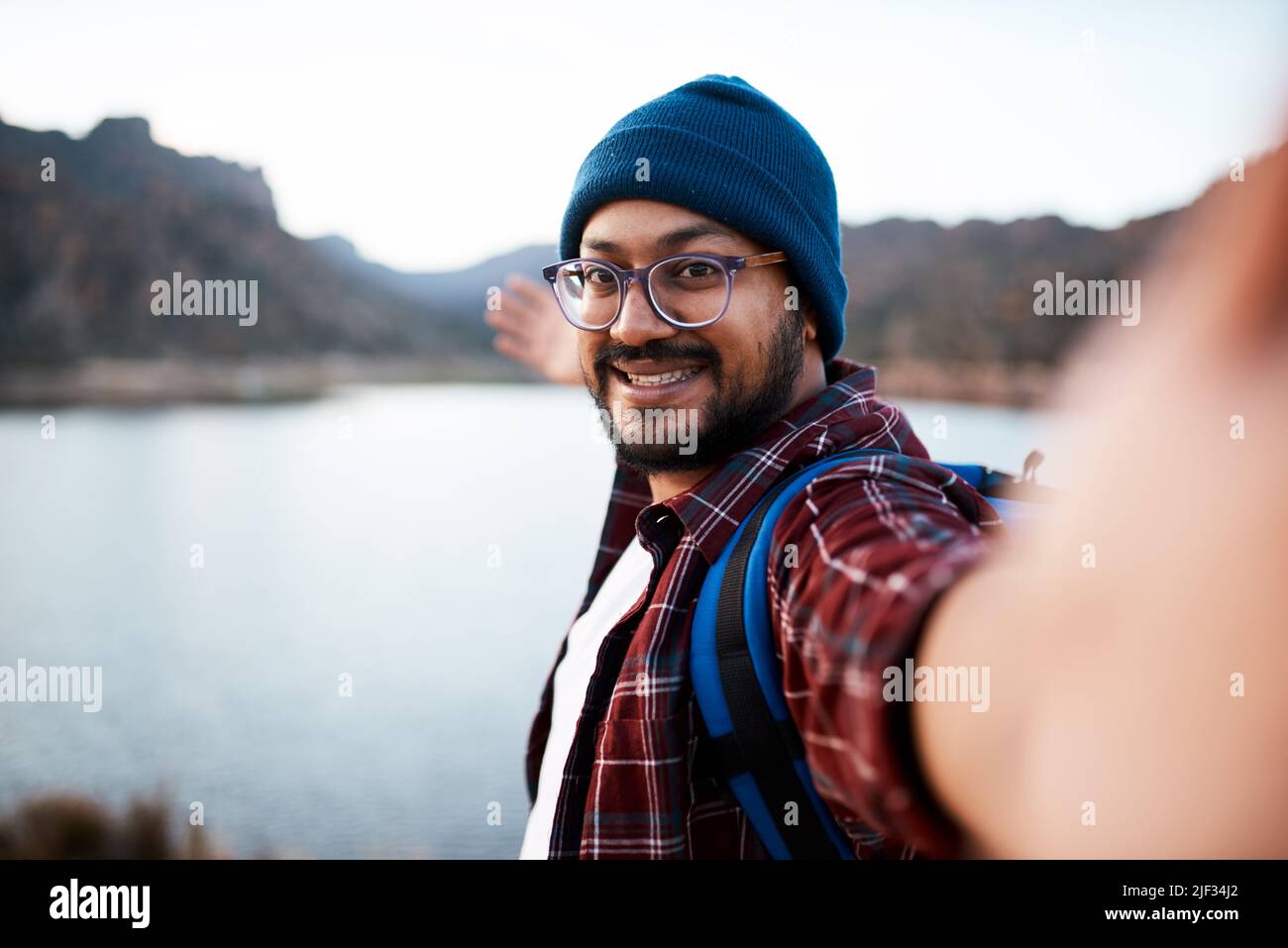 Un emballeur attrayant montre la vue sur le lac avec suivez-moi selfie lors d'un voyage de randonnée Banque D'Images