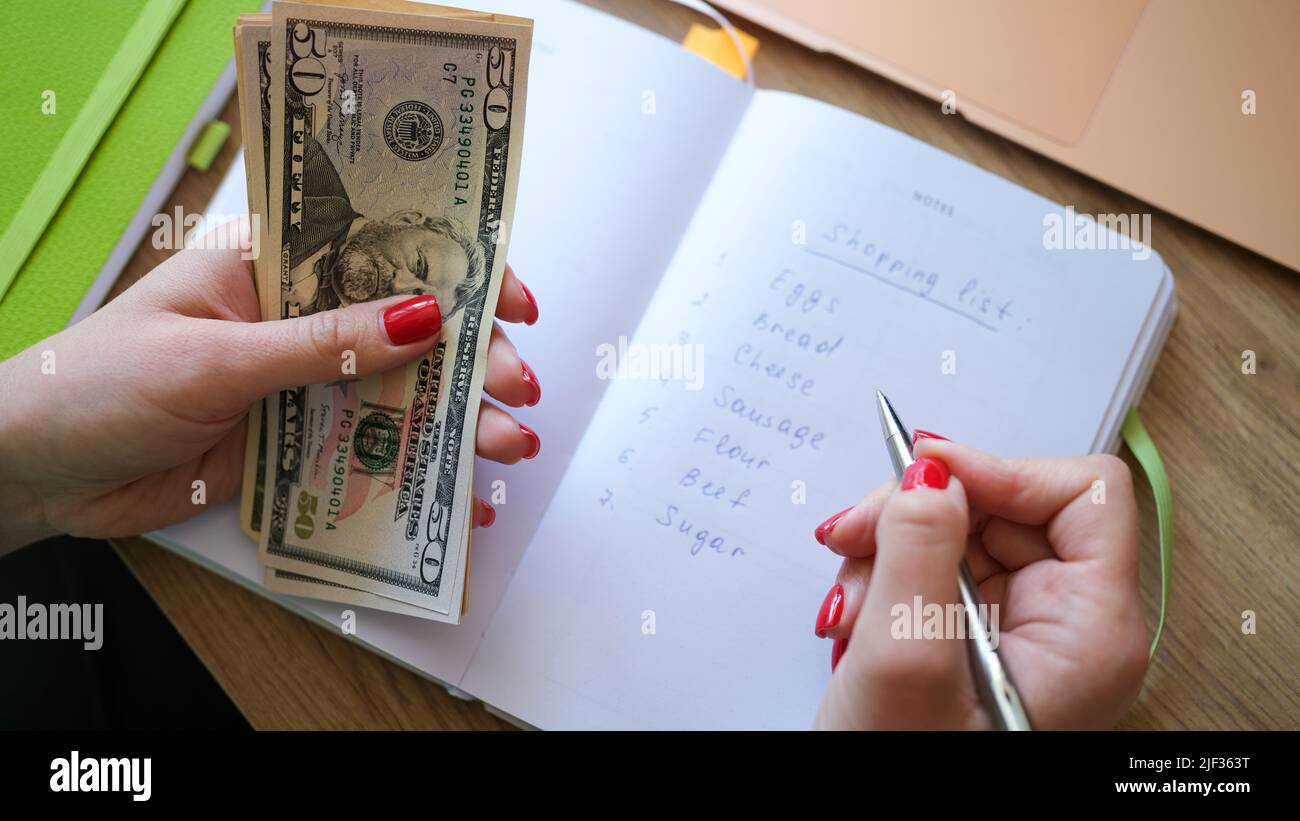 Les mains de femmes bloc-notes et plan de la liste des produits à acheter en magasin Banque D'Images